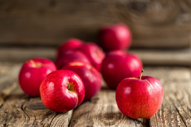 on an aged wooden surface are red apples