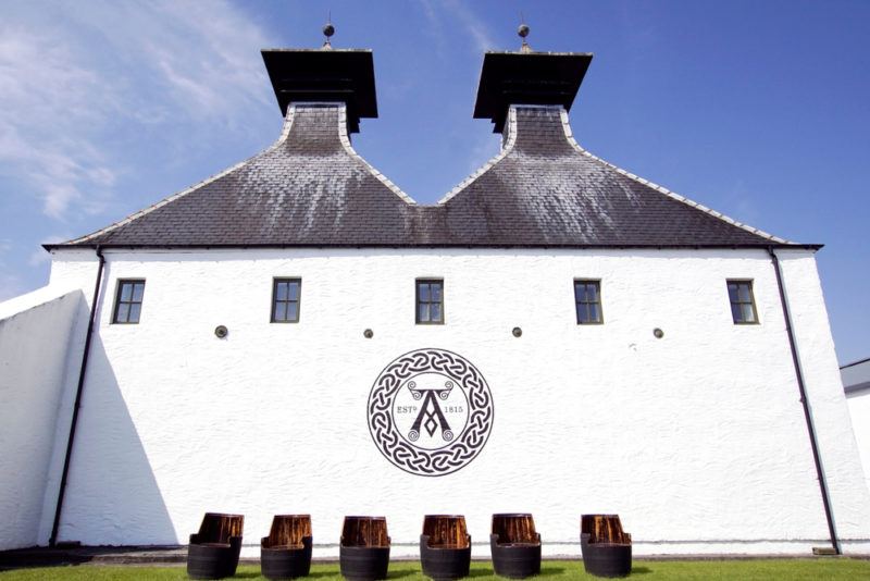 ardbeg distillery with used whisky barrels outdoors