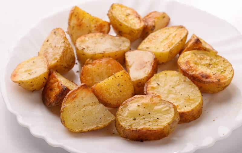 a closeup image of a white plate with baked potatoes