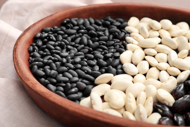 a clay dish with different types of black and white beans