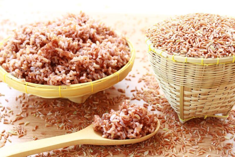 a bowl of cooked brown rice and a basket or raw brown rice next to each other to represent the best brown rice protein powder 