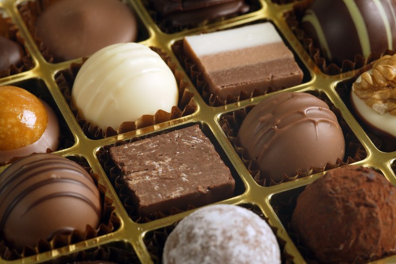 closeup of box of chocolates includes white, caramel, truffle, and fudge. This is just one type of chocolate subscription box available.