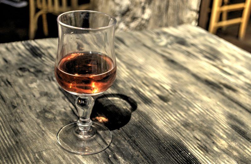 a glass of cognac on an outdoor wooden table 