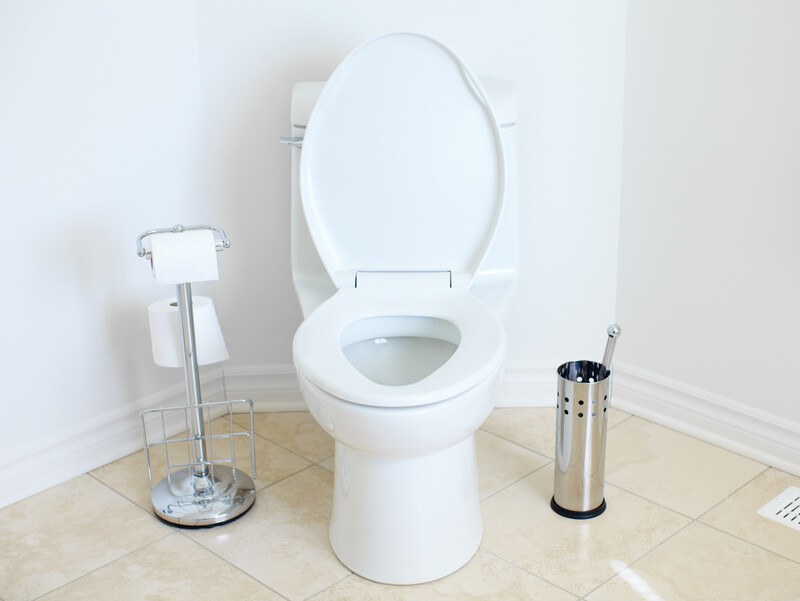 best foods pooping | Food For Net This photo shows a white toilet with the lid up in a bathroom with white walls, beige tiles, and chrome accessories, representing the best foods for pooping.