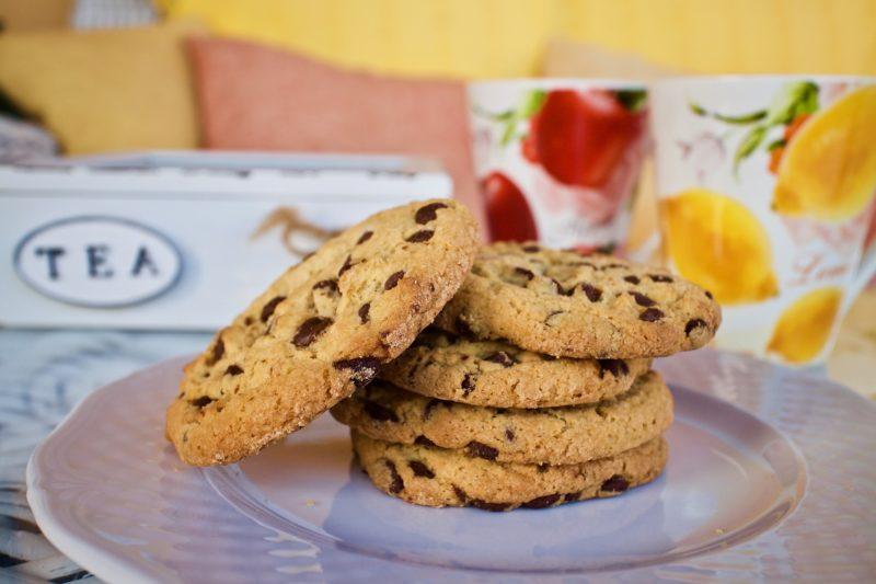 plate of four gluten free cookies stacked with one cookie falling over from a gluten free subscription box