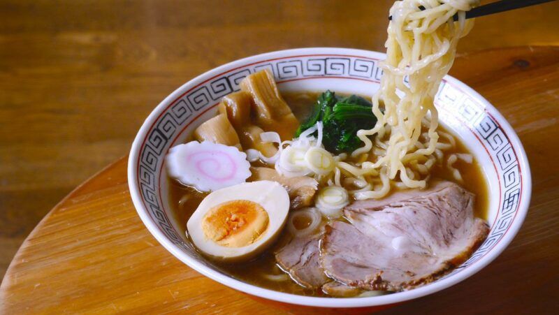 a bowl of ramen noodles with meat, eggs, and veggies to represent the best instant ramen brands