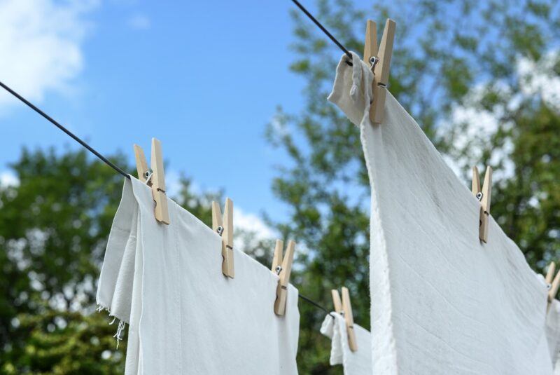 best-plant-based-detergent | Food For Net two sheets held to clotheslines with clothespins with the blue sky in the background to represent the best plant-based laundry detergent