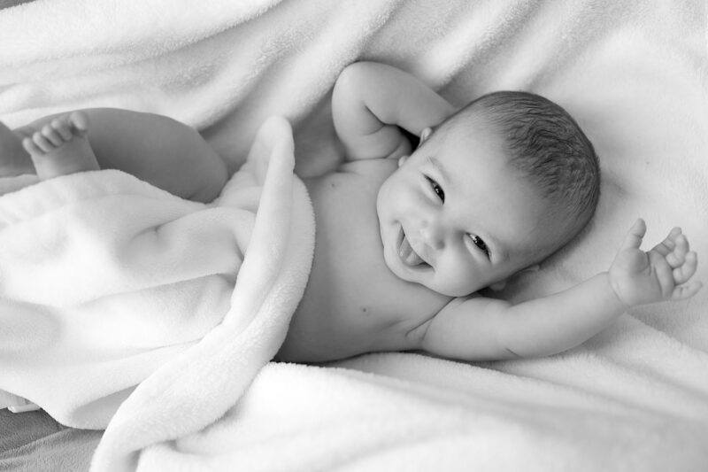 best-plant-based-diapers | Food For Net a smiling baby wrapped in a soft blanket to represent the best plant-based diapers
