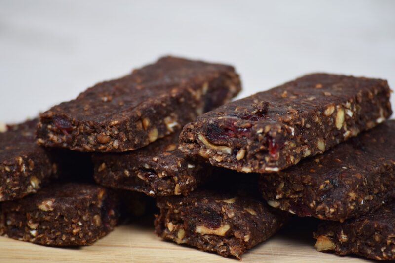 a close up of several dark colored bars with nuts and fruit in them to represent the best plant-based protein bars 