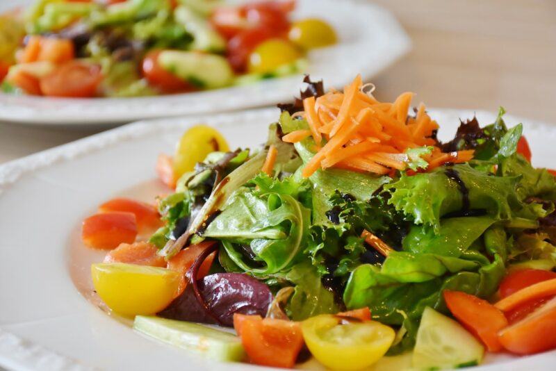 best-plant-based-salad-dressing | Food For Net close up of a fresh salad with another one in the background to represent the best plant-based salad dressing