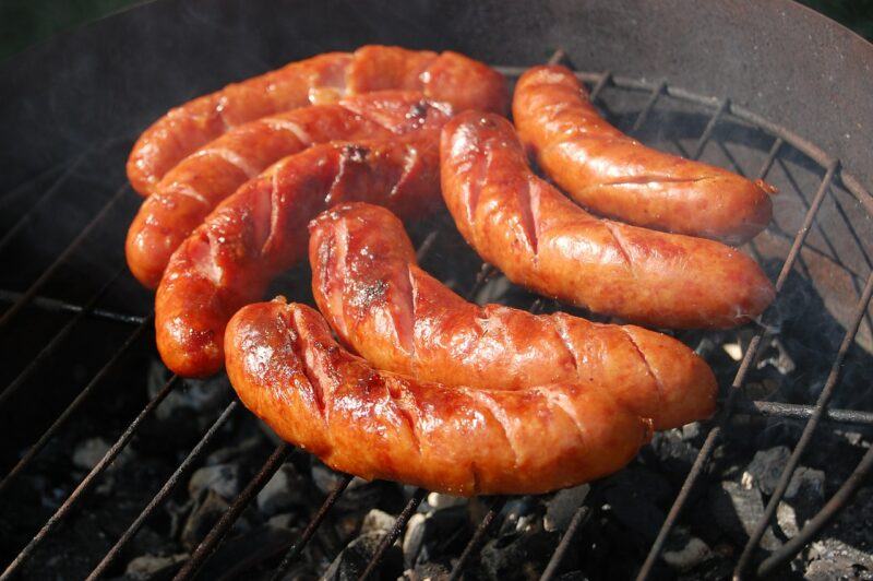 several browned sausages on a charcoal grill to represent the best plant based sausage brands 