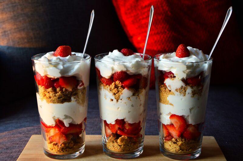 three yogurt parfaits lined up with fruit and granola in them to represent the best plant-based yogurt 