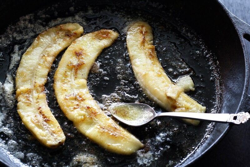 bananas frying in a frying pan to represent the best rum for bananas foster 