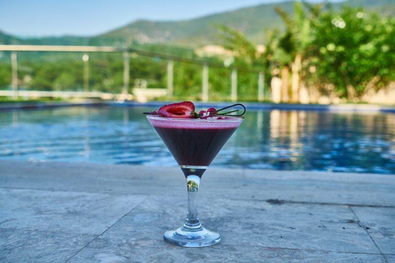 a purple cocktail sitting by the pool to represent the best russian vodka 