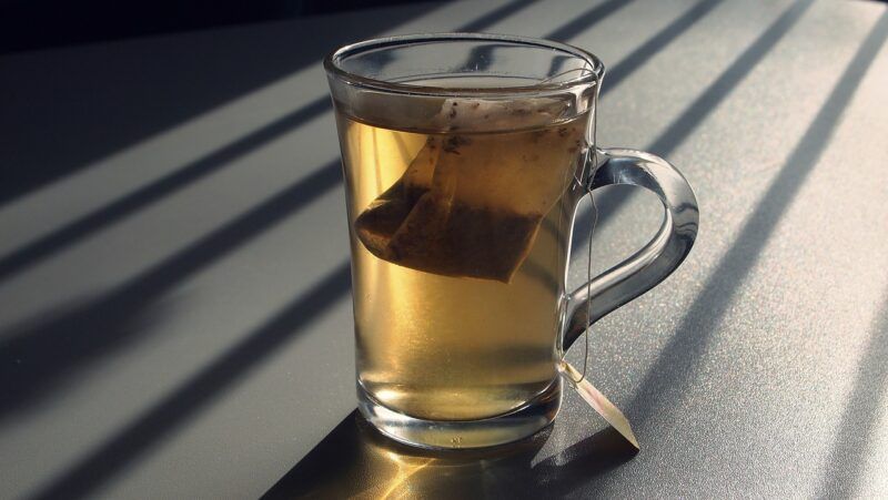 a mug with a tea bag in it on a table in a ray of sunlight to represent the best sweet tea vodka