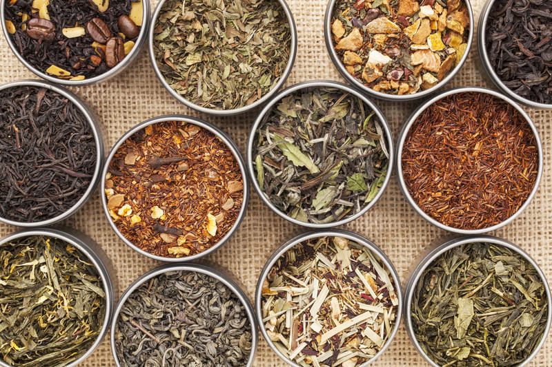 varieties of dry, loose leaf teas with colors ranging from green, white, red, and black and citrus peels