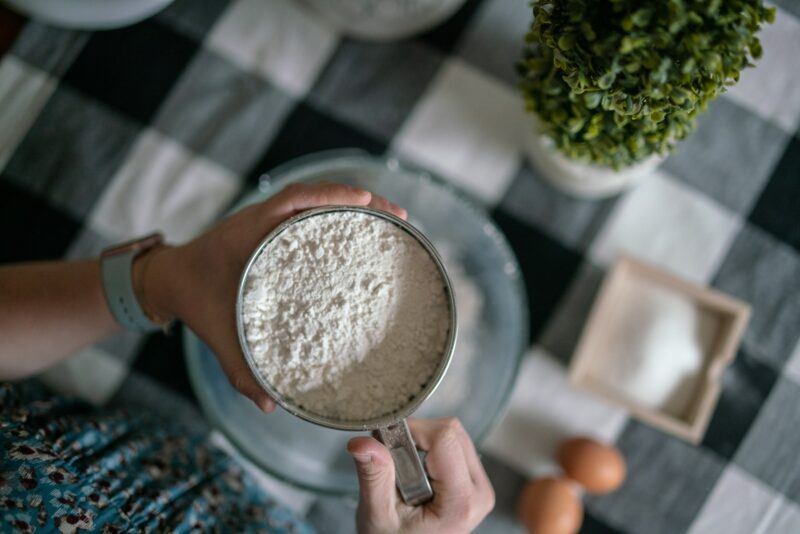 A plain white powder in a scoop over a bowl to represent the best unflavored protein powder 