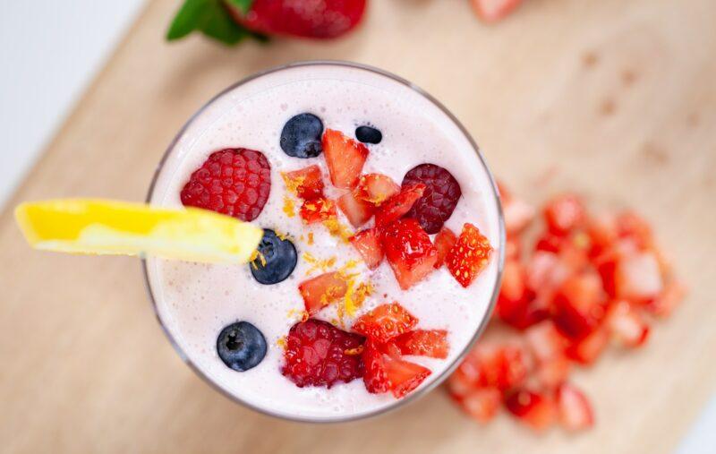 Close up view of the top of a fruit smoothie with fruit garnish to represent the best unsweetened protein powder 