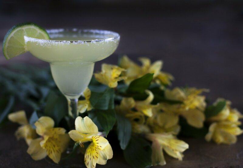 a yellow, citrus drink surrounded by yellow flowers to represent the best vodka for limoncello 