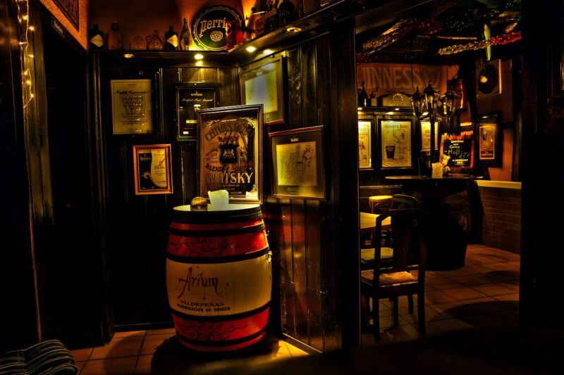 a cozy pub with a decorative whiskey barrel nestled in the corner to represent the best way to drink whiskey