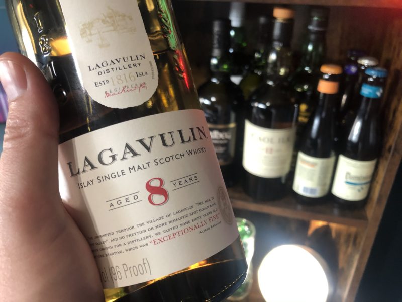 bottle of lagavulin 8 close up with other scotch in the background