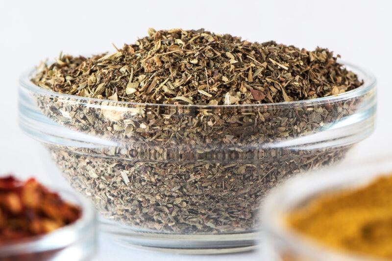 a closeup shot of a clear glass bowl of Italian seasoning