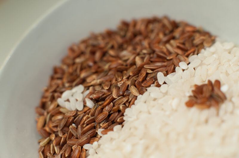 a closeup image of a bowl with brown and white rice grains