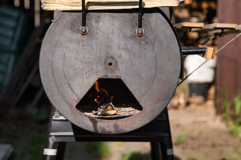 burning wood inside vintage offset barrel smoker