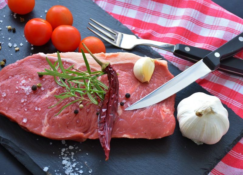 meat surrounded by garnish and vegetables to represent where to buy fresh beef online 