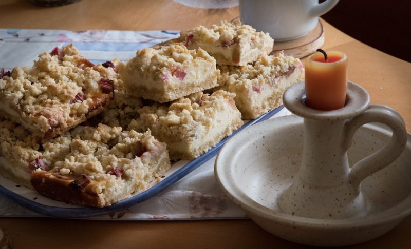 strawberry rhubarb bars on a plate next to a candle to represent where to buy fresh rhubarb online 