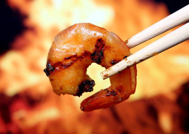 a piece of cooked shrimp in chopsticks to represent where to buy fresh shrimp online 