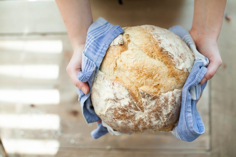 Someone holding a loaf of freshly baked bread to represent where to buy fresh yeast online 