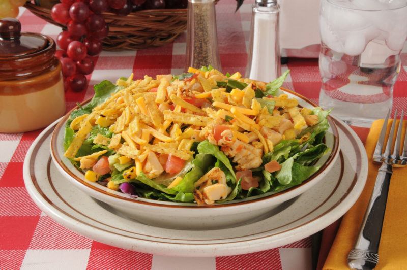 taco bowl composed of ground turkey, lettuce, other vegetables like tomatoes and topped with shredded cheese