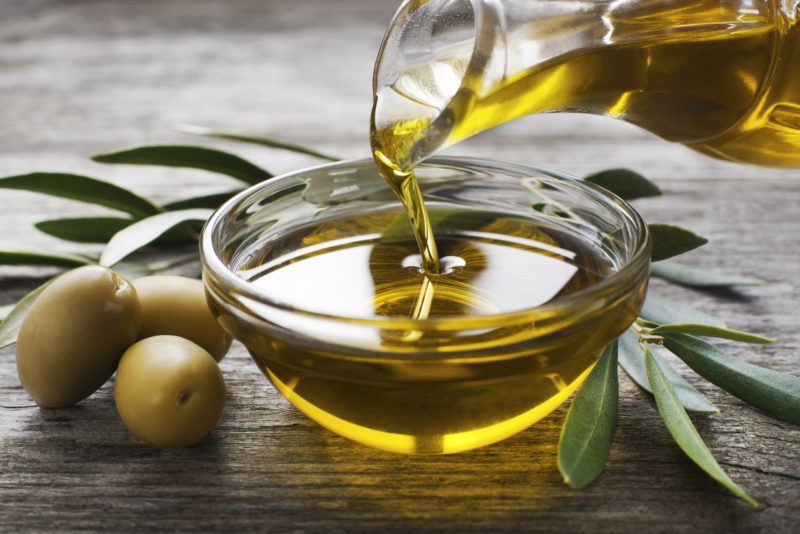 olive oil from a container being poured on a glass bowl | Food For Net olive oil dispenser pouring our olive oil on a glass bowl