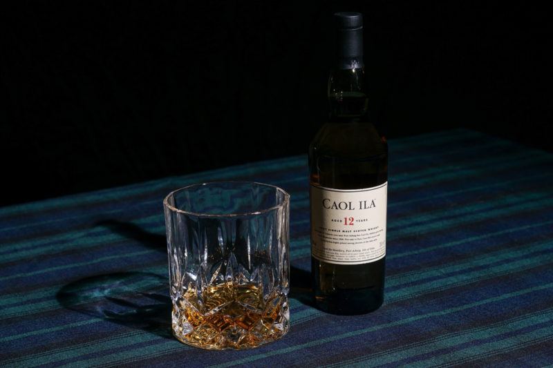 caol ila 12 scotch bottle with clear crystal glass on plaid table cloth