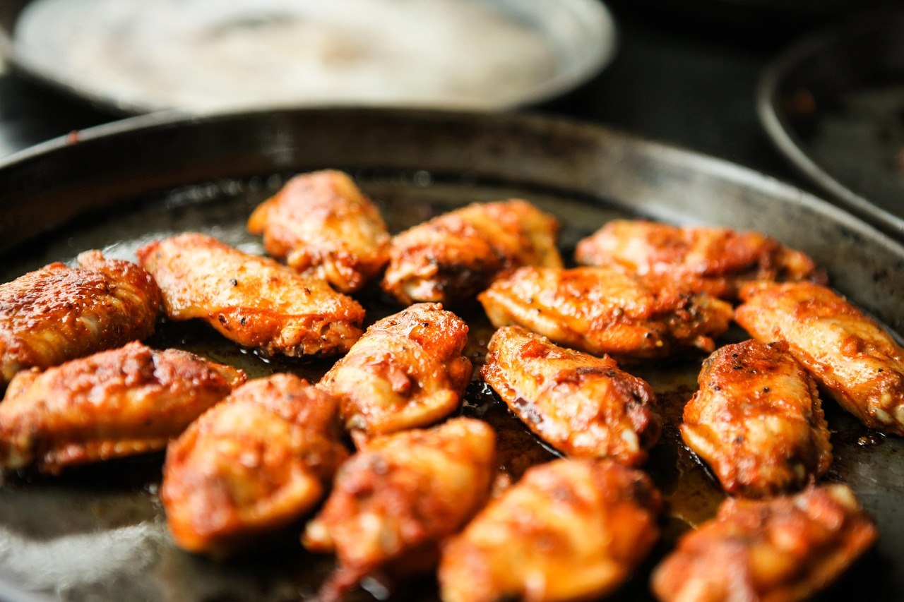 about 10 chicken wings covered in hot sauce.