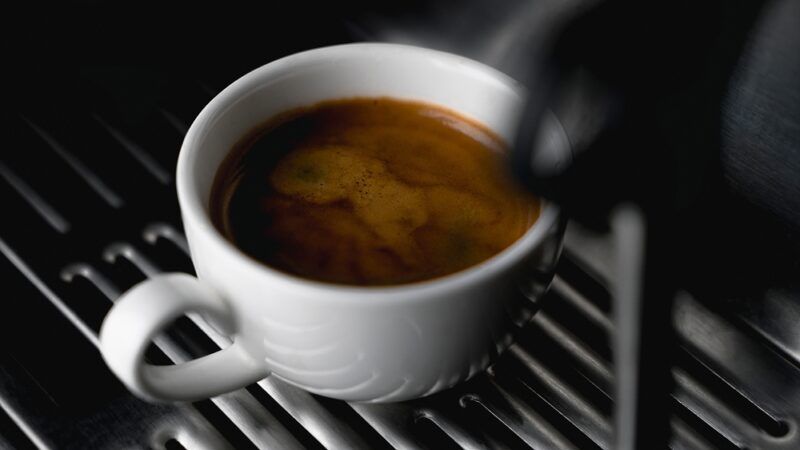 closeup image of a white cup of coffee fresh from the coffee maker