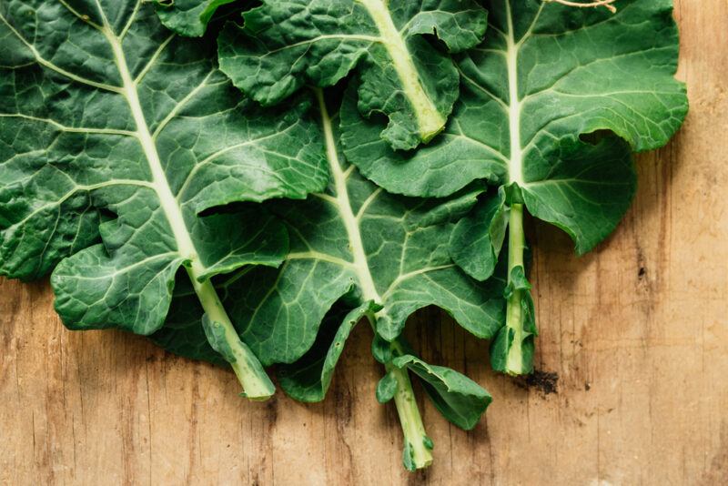 on a wooden surface is a spread of few collard greens