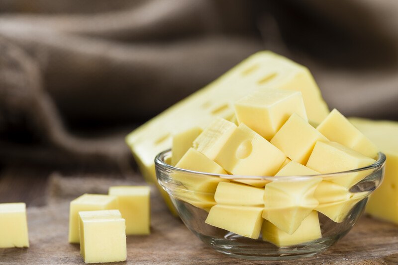 a closeup image of a clear glass full of cubed cheese