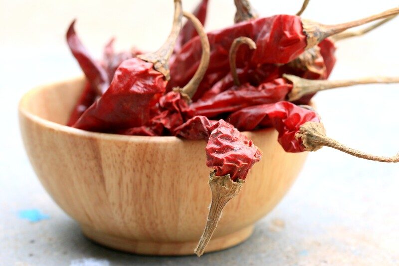 closeup image of a wooden bowl full of dehydrated chili