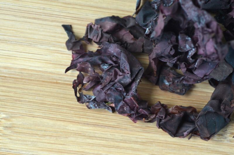 on a wooden surface is a pile of dried dulse