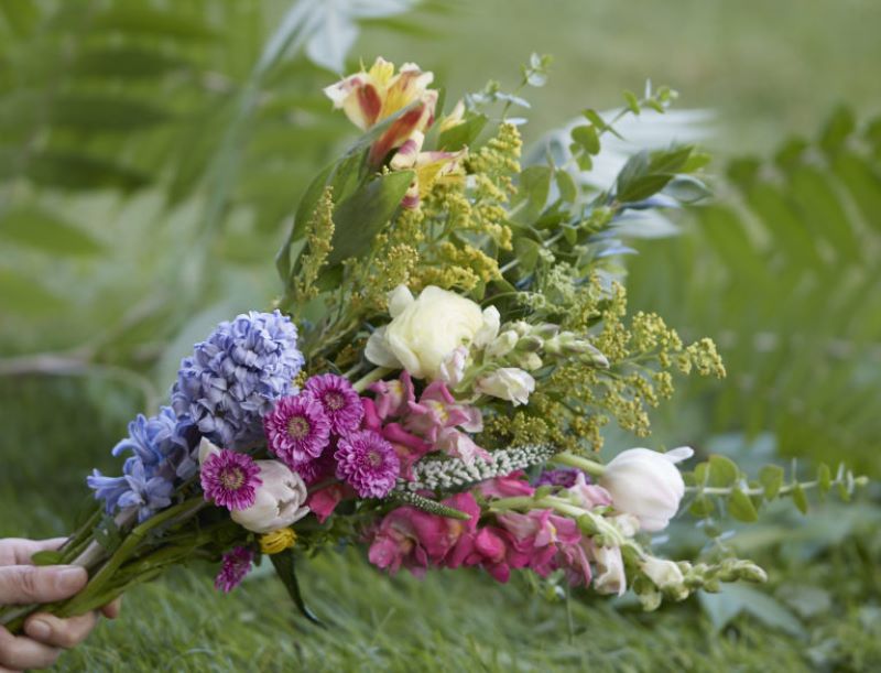 Beautiful soft colored wild flower bouquet in someone's hand 