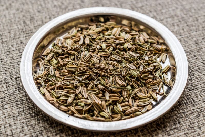 on a tan-colored napkin is a metal plate with fennel seeds