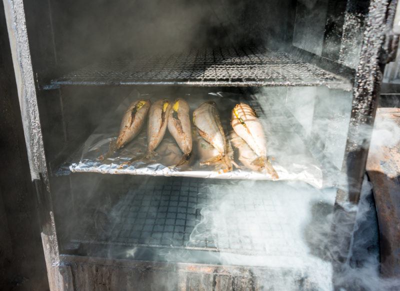 fish stuffed with herbs in vertical smoker