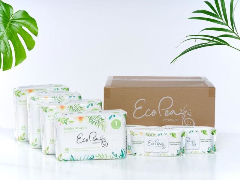 four packages of eco pea diapers, to the right a brown cardboard eco pea box and two eco pea wipes on a white background