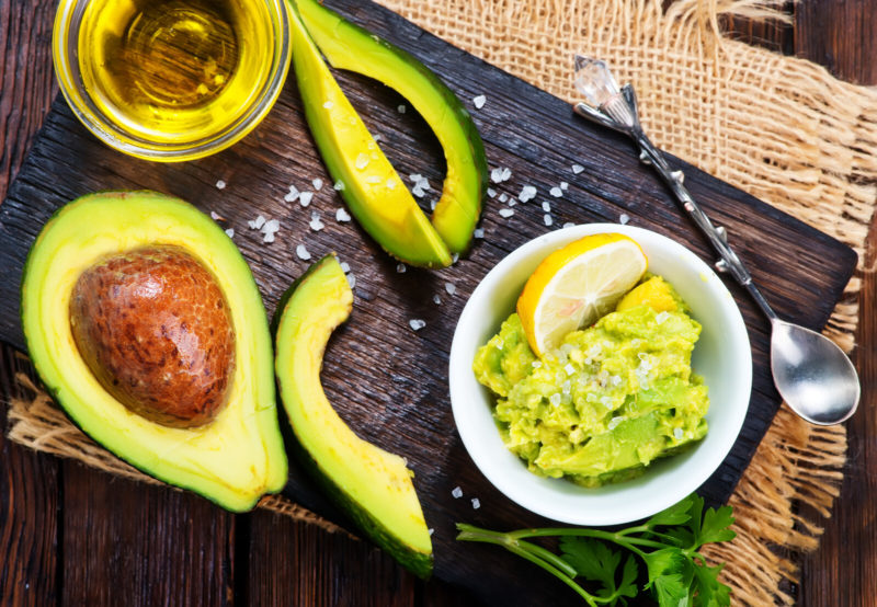 avocado that has been sliced and mashed avocado on a small, white bowl