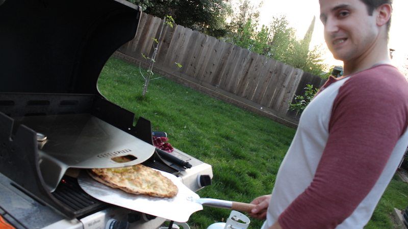 pizza peel and kettlepizza on gas grill making olive oil flatbread