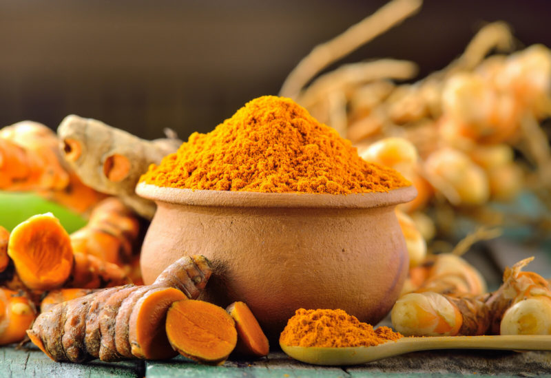 fresh turmeric and ground turmeric on a bowl