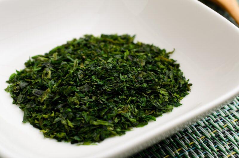 closeup image of a white dish with dried green laver or aonori