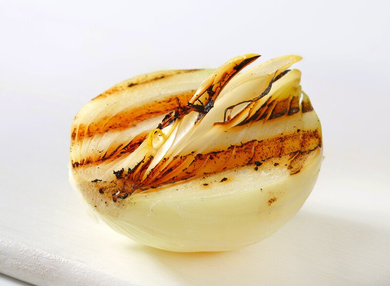 a closeup shot of a grilled white onion with grill marks